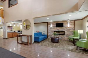 a lobby with a blue couch and a fireplace at Comfort Inn & Suites Cedar Rapids North - Collins Road in Cedar Rapids