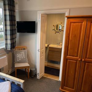 a bathroom with a sink and a mirror at TRETHEWEY GUEST HOUSE in Fowey