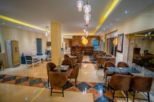 ein Restaurant mit Tischen und Stühlen in einem Zimmer in der Unterkunft Blumar El Dome Hotel in Ain Suchna
