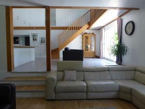 sala de estar con sofá y escalera en La Maison Barthélemy: Voie Verte et piscine, en Bellegarde-du-Razès