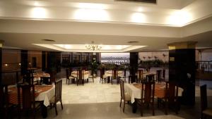 a restaurant with tables and chairs and a chandelier at Lotus Luxor Hotel in Luxor