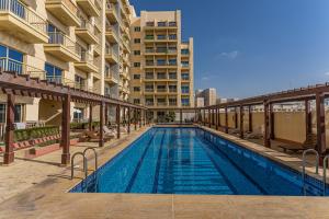 uma piscina em frente a um edifício em HiGuests - Luxurious 1BR Apartment with balcony in JVC em Dubai