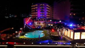 a pool in the middle of a city at night at Lotus Luxor Hotel in Luxor