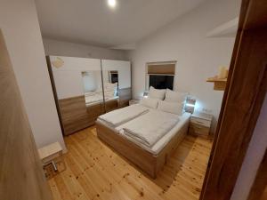 a small bedroom with a bed and a wooden floor at elephants Ferienhaus Haus Ost in Jahnsdorf
