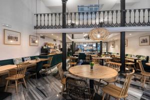 une salle à manger avec des tables et des chaises en bois dans l'établissement Petit Palace Plaza de la Reina, à Valence