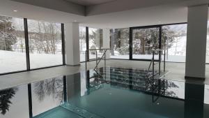 - une piscine dans une maison enneigée dans l'établissement Studio 20qm mit Balkon und Innenpool - 22010, à Schluchsee