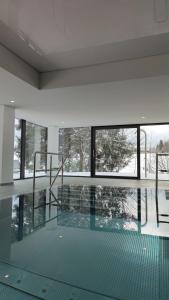 une piscine dans un immeuble avec une grande fenêtre dans l'établissement Studio 20qm mit Balkon und Innenpool - 22010, à Schluchsee 13 autres photos