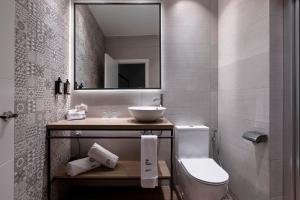 une salle de bain avec un lavabo, des toilettes et un miroir dans l'établissement Petit Palace Plaza de la Reina, à Valence 34 autres photos