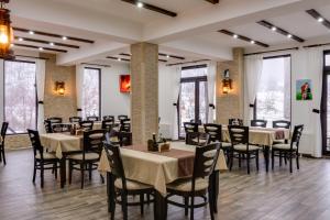 a dining room with tables and chairs and windows at Family Hotel LILIUM in Kirkovo