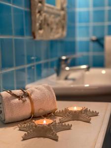 a bathroom with two candles and a towel and a sink at Rokkaria Holidays Apartments in Villasimius