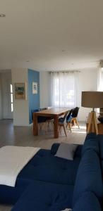威斯特拉姆的住宿－Maison moderne plein coeur de Ouistreham，客厅配有蓝色的沙发和桌子