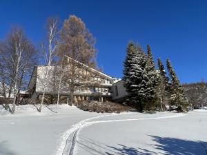 a house in the snow with a trail in the snow at Apartmány Snow v centre Starého Smokovca in Smokovce