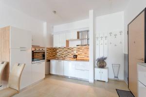 a kitchen with white cabinets and a counter top at Marina Apartment in Bečići