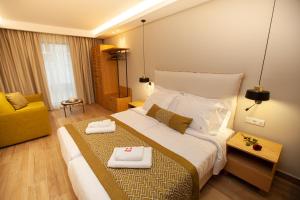 una habitación de hotel con una cama grande y una silla amarilla en No21 Luxury Suites, en Tesalónica