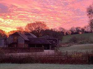 an old house in a field with a sunset at Renovated Loft on Working Farm in Mayfield