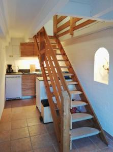 a wooden staircase in a kitchen next to a kitchen at Alte Stellmacherei - Ferienwohnung 2 in Riepsdorf