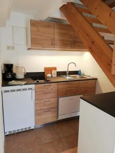a kitchen with wooden cabinets and a sink at Alte Stellmacherei - Ferienwohnung 2 in Riepsdorf