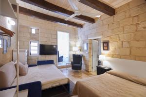 1 dormitorio con 2 camas y TV en una habitación en Casa San Carlo, en La Valeta