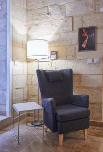 una silla y una lámpara junto a una mesa en Casa San Carlo, en La Valeta