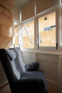 Casa San Carlo في فاليتا: غرفة معيشة مع أريكة ونافذة