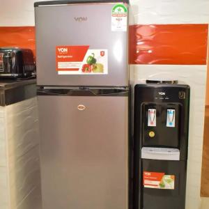 a refrigerator and a water dispenser in a kitchen at Wawa Lifestyle Regency one bedroom Apartment in Nairobi