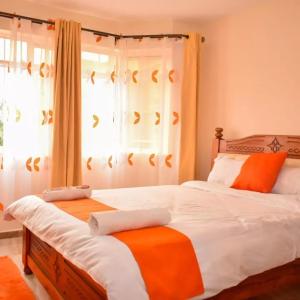 a bedroom with two twin beds and a window at Wawa Lifestyle Regency one bedroom Apartment in Nairobi
