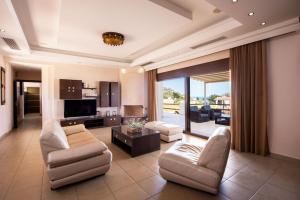 a large living room with a couch and chairs at Villa Pasithea in Faliraki