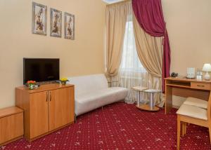 a living room with a white couch and a television at Lermontovskiy Hotel in Odesa