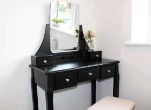 a black dresser with a mirror on top of it at Abingdon - Private Flat with Parking 09 in Abingdon