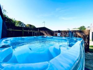 a large blue pool of water in a yard at 5 Bed Barn Conversion - with private hot tub in Birchington