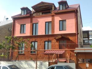 een rood bakstenen gebouw met een gambrel dak bij Spacious apartment in Aygedzor street in Jerevan