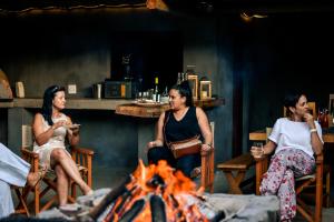 un grupo de personas sentadas alrededor de un fuego en Royal Karoo Safari Lodge, en Steytlerville
