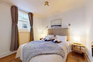 Un dormitorio con una cama grande y una ventana en Park Lane Apartments - Clarges Street, en Londres