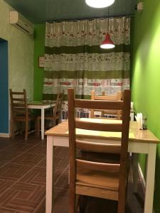 - une salle à manger avec une table, des chaises et un rideau dans l'établissement Mini-Hotel Spi Zdes, à Khabarovsk