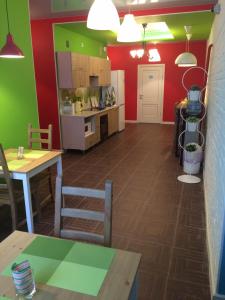 cocina con mesa y paredes de color verde y rojo en Mini-Hotel Spi Zdes, en Khabarovsk