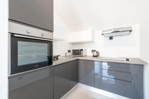 a kitchen with stainless steel cabinets and a microwave at Apartments Marando in Dubrovnik