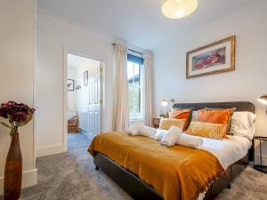 a bedroom with a large bed with orange and white pillows at Pass the Keys Cosy terrace within city walls ideal for exploring in Canterbury