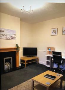 sala de estar con TV y chimenea en Town centre stay Northumberland FREE WIFI AND CLOSE TO BEACH, en Blythe