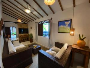 ein Wohnzimmer mit zwei Sofas und einem Fernseher in der Unterkunft Pousada Jequitibá in Trancoso