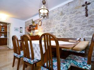 a dining room with a stone wall and a wooden table and chairs at Holiday Home Stara Lipa in Baška Voda