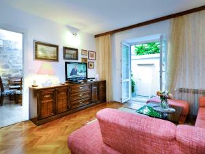 a living room with a couch and a tv at Holiday Home Stara Lipa in Baška Voda