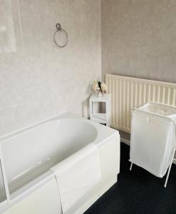 een witte badkamer met een bad en een wastafel bij Town centre stay Northumberland FREE WIFI AND CLOSE TO BEACH in Blythe