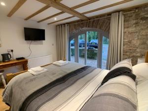 a bedroom with a large bed and a television at Swan House Tea Room and Bed & Breakfast in Lydney