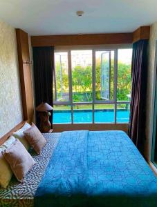 a bedroom with a large bed and a swimming pool at Baan View Viman by PW in Hua Hin