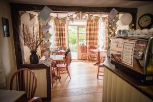Swan House Tea Room and Bed & Breakfast في ليدني: غرفة طعام مع طاولة وكراسي وساعة