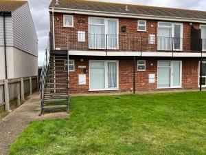 a brick house with a staircase in the yard at Gone To The Beach Flat 1 in Hunstanton