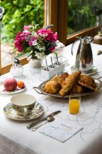 a table with a plate of pastries and juice and flowers at Le Clos Chedeville in Chartres