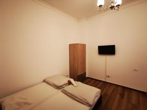 a small bedroom with a bed and a tv at Central Accommodation PIATA ROMANA in Bucharest