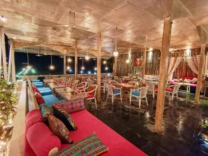 a restaurant with couches and tables and chairs at Chique Shanti Resort in Mandrem