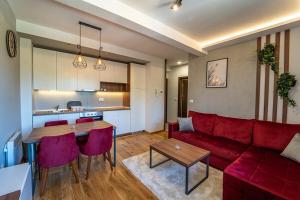 - un salon avec un canapé rouge et une table dans l'établissement Titova Vila Zlatibor, à Zlatibor